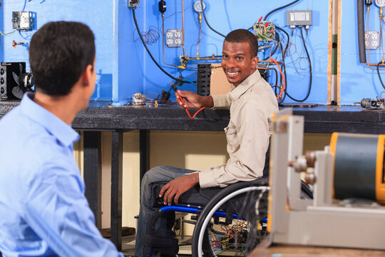 Student in wheelchair setting up HVAC experiment talking to another student