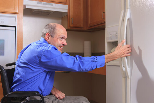 Man with Friedreich's Ataxia and deformed hands using his refrigerator