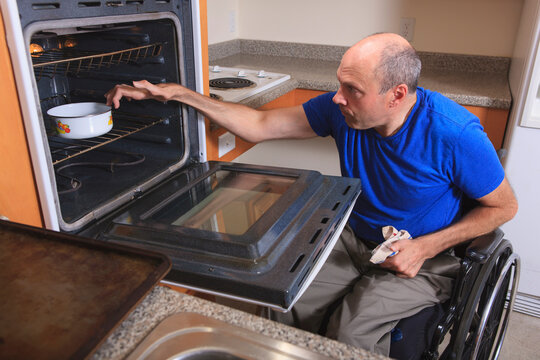 Man with Friedreich's Ataxia and deformed hands using his accessible oven