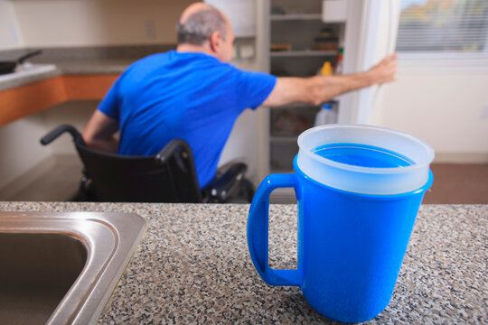 Man with Friedreich's Ataxia and deformed hands using his refrigerator