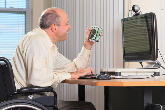Man with Friedreich's Ataxia and deformed hands as an electronic design engineer at his workstation