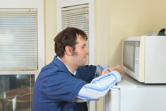 Man with Asperger's living in his home and cooking in microwave