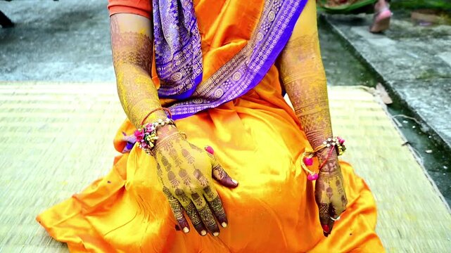 Close-up footage of a traditional Indian Haldi ceremony where family members and friends apply turmeric paste to the bride before marriage. The pre-wedding ritual symbolizes purification, blessings.