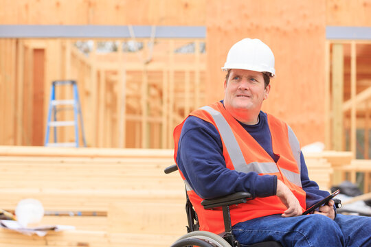 Construction engineer with spinal cord injury using tablet to take notes on site