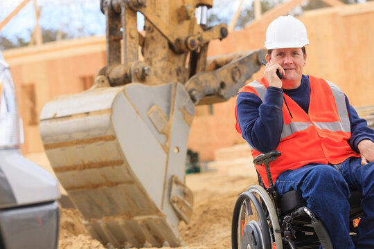 Construction engineer with spinal cord injury on radio to equipment operator