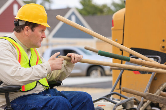 Construction supervisor with Spinal Cord Injury counting work tools on construction site