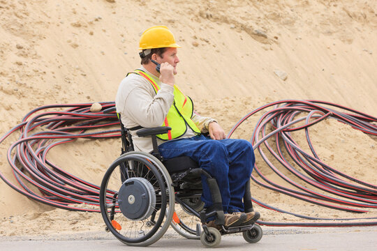 Construction supervisor with Spinal Cord Injury on walkie talkie with underground utility cables