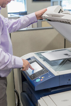 Male executive using photocopier at customer service center of electric power plant