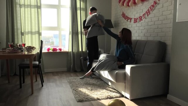 Mother and son fighting with pillows