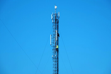 Obraz premium Maintenance staff at the work. High-altitude work. Worker repair cell tower