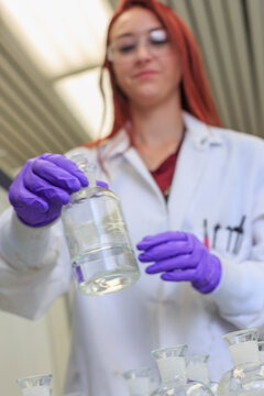 Lab chemist holding reagent bottle