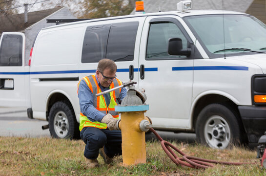Water department technician reinstalling caps on fire hydrant