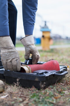 Technician preparing to use hydrant attachment with sensor for flushing mains