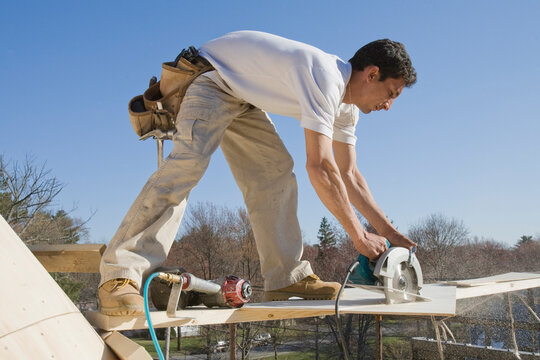 Carpenter cutting plank with a circular saw