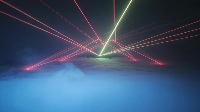 Dynamic laser light beams creating abstract patterns above glowing fog