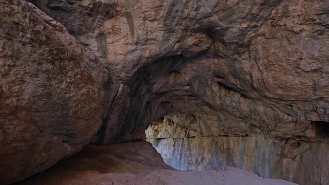Scenic interior of a natural rocky cave at a tourist destination, featuring textured stone walls, dark passages, and dramatic geology, ideal for travel, sightseeing, nature, and adventure content.