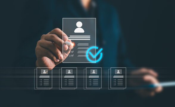 Businessman using stylus pen to evaluate candidates resume profiles for recruiting process. HR manager choosing standard resume for human resource hiring, talent acquisition and staffing concept