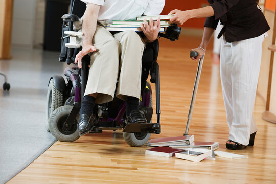 Man with Cerebral Palsy and woman holding books