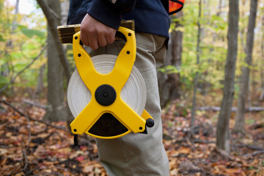 Engineer measuring a construction site with a tape measure