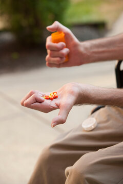 Man with Friedreich's Ataxia holding pills with degenerated hands