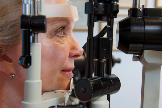 Woman getting eye exam with a slit lamp