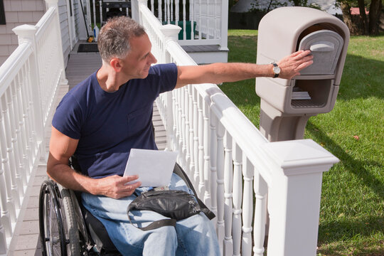 Man with spinal cord injury in a wheelchair getting his mails