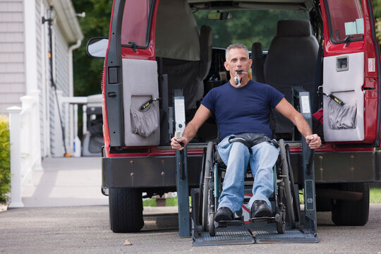 Man with spinal cord injury in a wheelchair getting in his accessible van