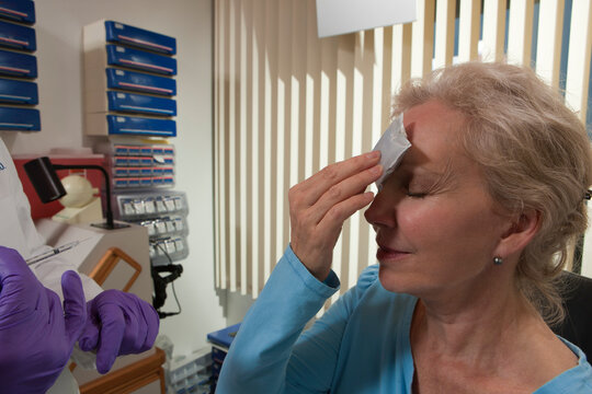 Patient applying ice on her forehead after a Botox treatment