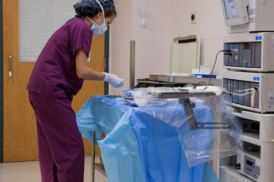 Surgical technologist setting up back table of instruments prior to surgery