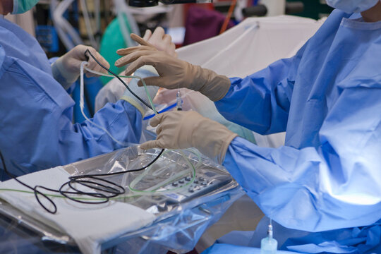 Surgical technologist passing a phaco hand piece to doctor during cataract surgery