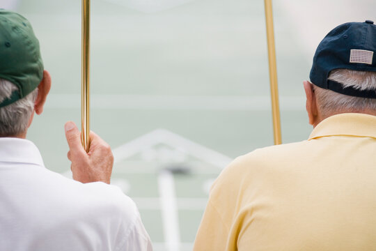 Rear view of two senior men holding shuffleboard cues