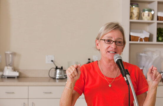 Senior female announcer making an announcement at luncheon