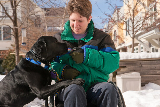 Woman with multiple sclerosis giving keys to a service dog in the snow