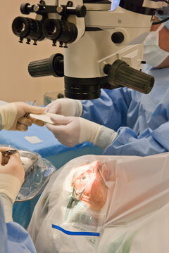 Surgical technologist passing suture to doctor for cataract surgery