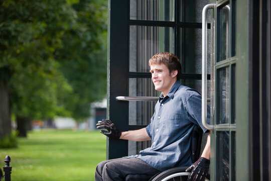 Man with spinal cord injury in a wheelchair exiting door of public parking lot