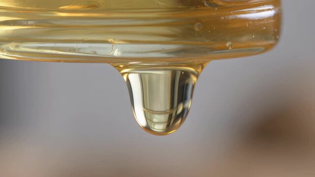 Golden Honey Dripping from Jar Lid, Sweet Natural Food Ingredient Close-up