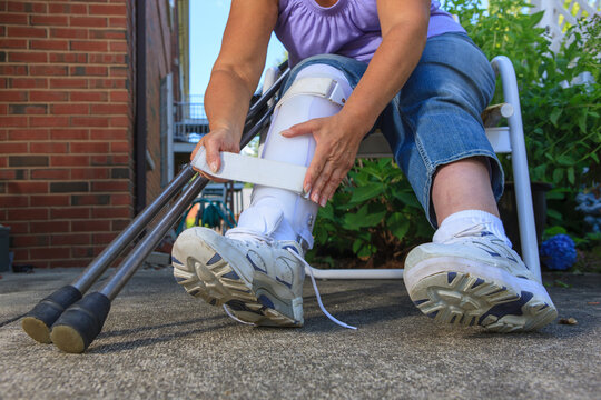 Woman with Spina Bifida adjusting leg brace so she can walk