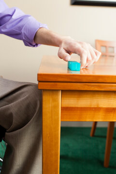 Disabled man picking up pill case