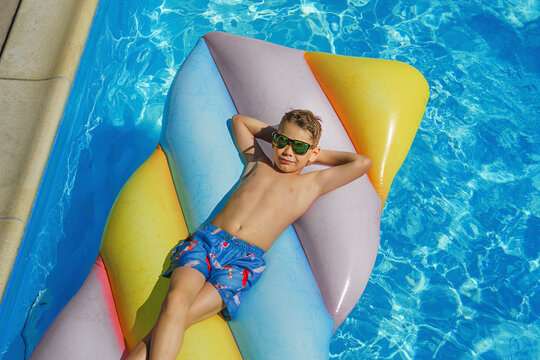 Child in swimming pool. Having fun on vacation at the hotel pool. Colorful vacation concept.