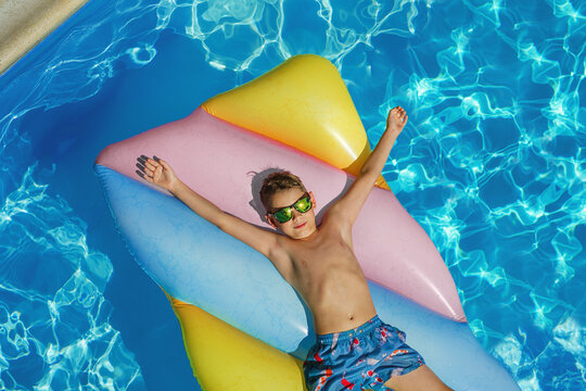 Child in swimming pool. Having fun on vacation at the hotel pool. Colorful vacation concept.