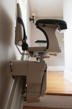 Motorized stair lift chair at top of stairs