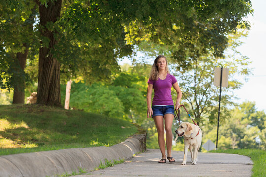 Woman with visual impairment walking with her service dog