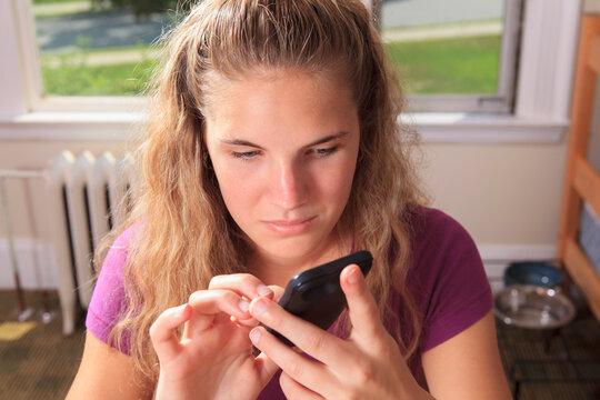 Student with visual impairment using her cell phone in her dorm room