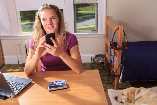 Student with visual impairment using her cell phone in her dorm room
