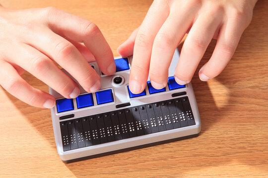 Student with visual impairment using her Braille display to communicate