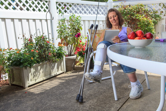 Woman with Spina Bifida writing notes while resting leg in a brace
