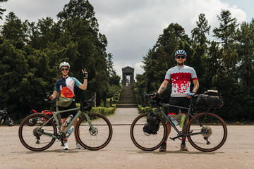 Obraz premium Two cyclists posing with gravel bicycles during an outdoor journey. Active travel and adventure lifestyle concept