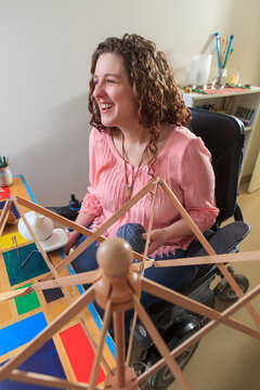 Woman with Muscular Dystrophy working with her umbrella yarn winder while in her power chair