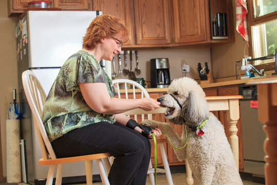 Woman with RSD feeding her service dog