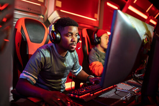Young men playing esports on gaming pcs in arena